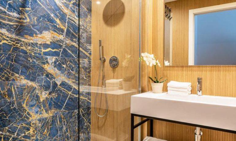 Elegante bagno con marmo blu e doccia moderna.