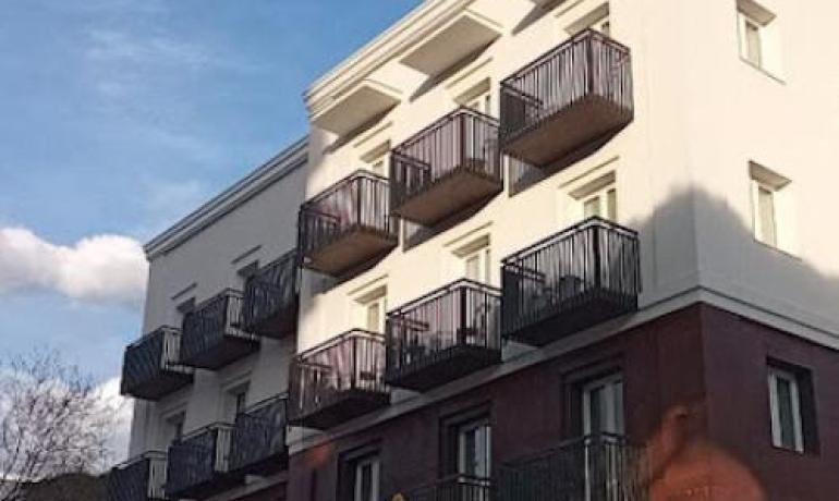 Edificio moderno con balconi neri e pareti bianche.